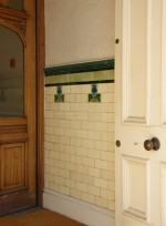 Entrance of Vicarage Chambers with a dado of plain tiles with insets of Art Nouveau tiles