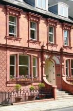 Facade of Vicarage Chambers in Park Square covered with pink terracotta and white faience over the doorway dated 1908